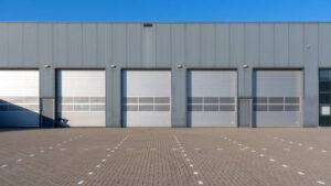 Row Of Grey Industrial Units With Roller Shutter Doors.